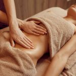 masseuse_massant_ventre_jeune_femme_sur_table_massage