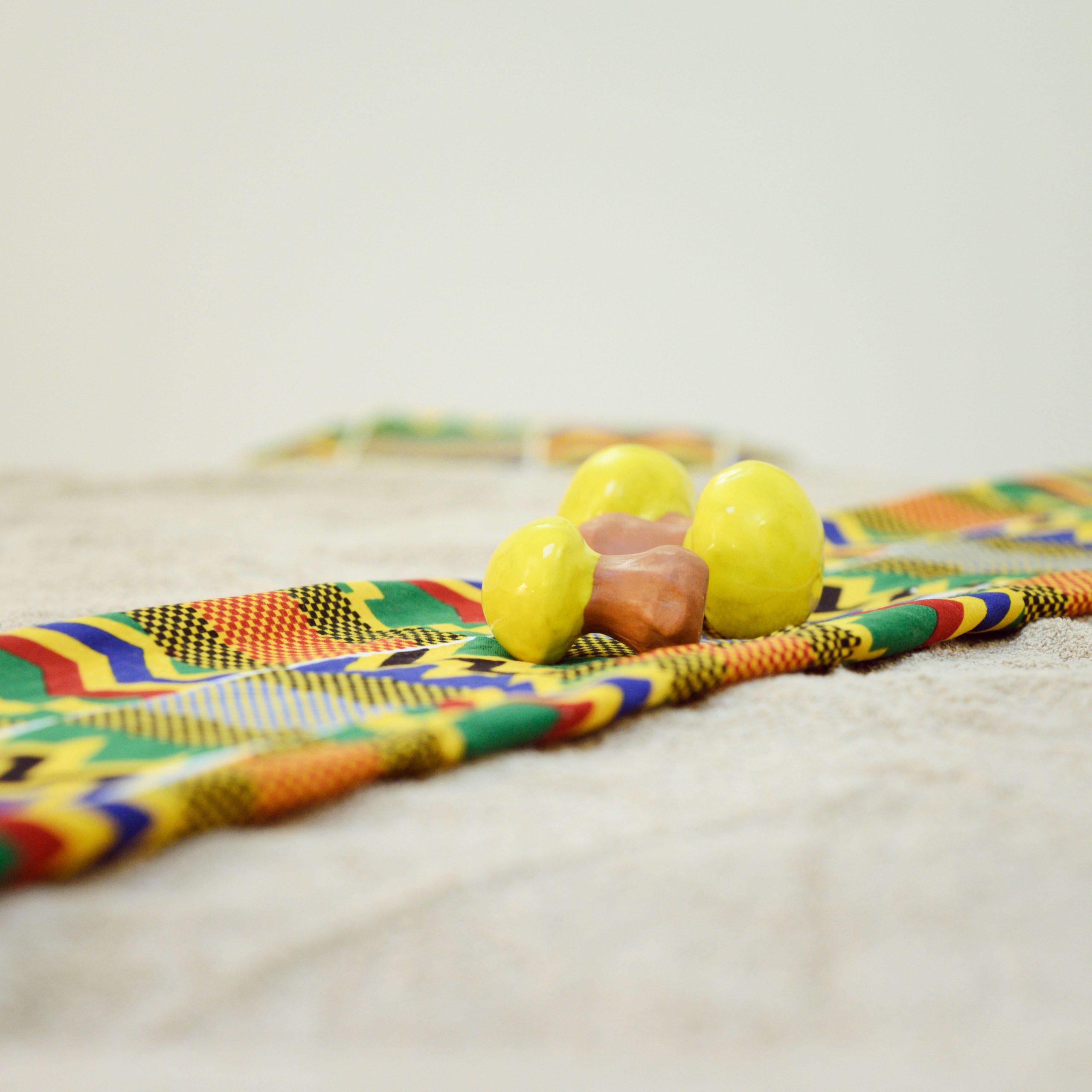 poignees bamileke pagne kente sur table massage